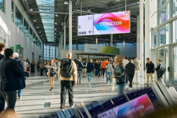 Nord Boulevard der Kölnmesse, Besucherinnen bewegen sich durch auf dem Messegelände, LED Bildschirm zeigt Videomaterial der DMEXCO 2026