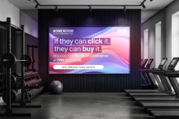 Bildschirm im Fitnessstudio, Werbeanzeige für die World of Commerce der DMEXCO 2026, dunkle Sportgeräte, Betonboden und Bildschirm zentral auf der Wand
