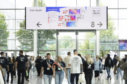 Digital signage der DMEXCO zeigt den Hallenplan und das Leitsystem f&uuml;r die Besucher, gro&szlig;e Menschenmasse laufen durch die Halle
