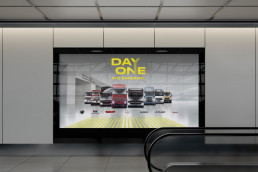 Visual von Daimler Truck Day One, Billboard in Station mit Rolltreppen im Vordergrund