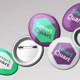 Buttons mit dem Logo des Unternehmens SmartQuart in t&uuml;rkis, lila und wei&szlig;,