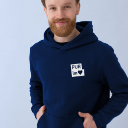 Junger Mann tr&auml;gt Hoodie mit der Grafik der Volksbank Pur Kampagne Pur im Herzen