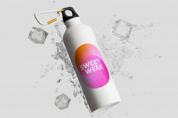 Trinkflasche mit der Grafik für die ISM Cologne, Wasser und Eiswürfel um die Flasche herum im dreidimensionalem Raum